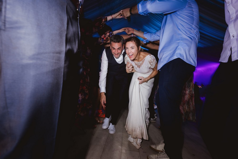 Couple de mariés passant sous les bras de leurs invités